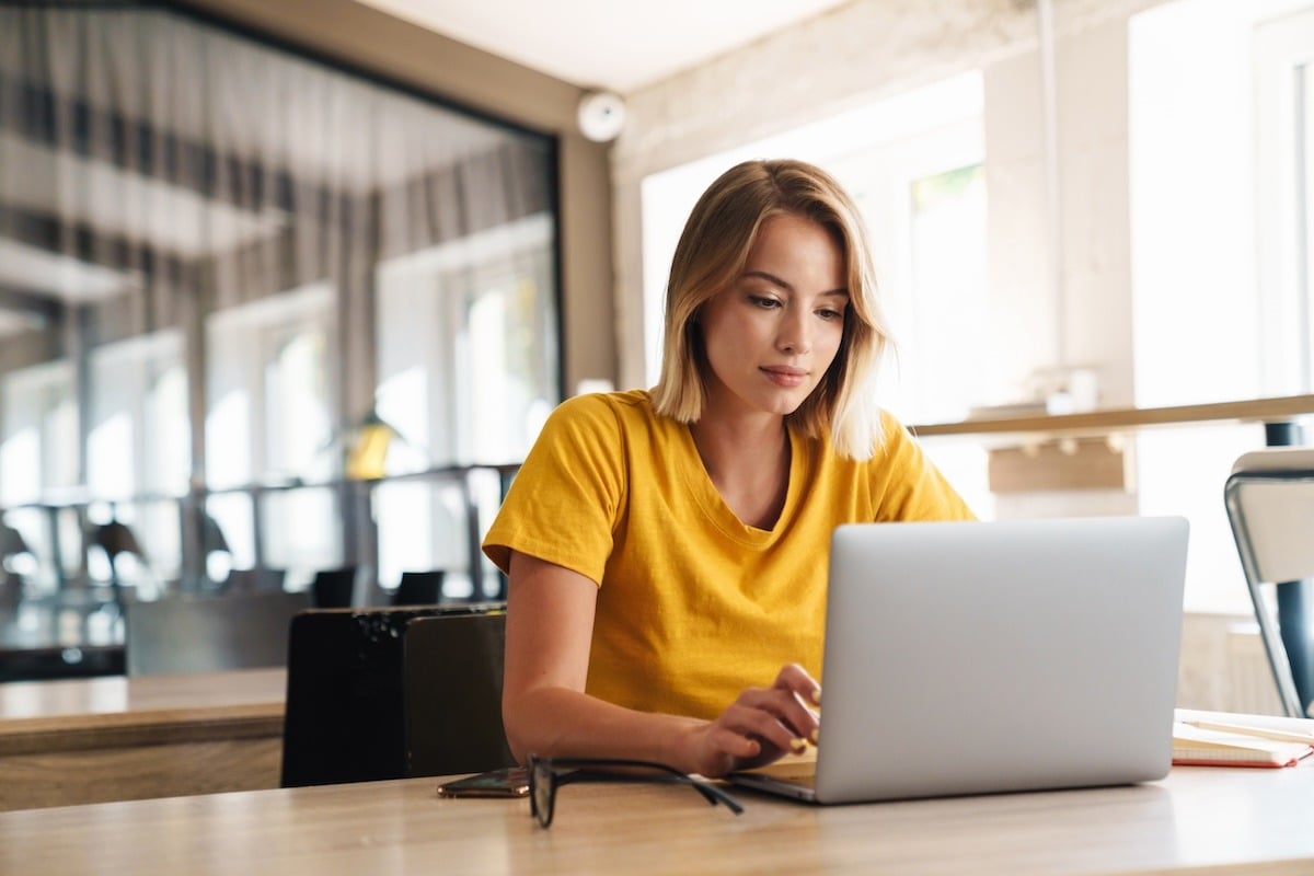 Woman with amazingly yellow t-shirt working at a laptop